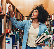 Lady picking books of the shelf in a library